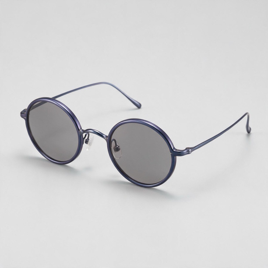 Óculos CALIBRE 19 em três quartos: armação redonda em titânio anodizado azul-violeta com lentes fumê.